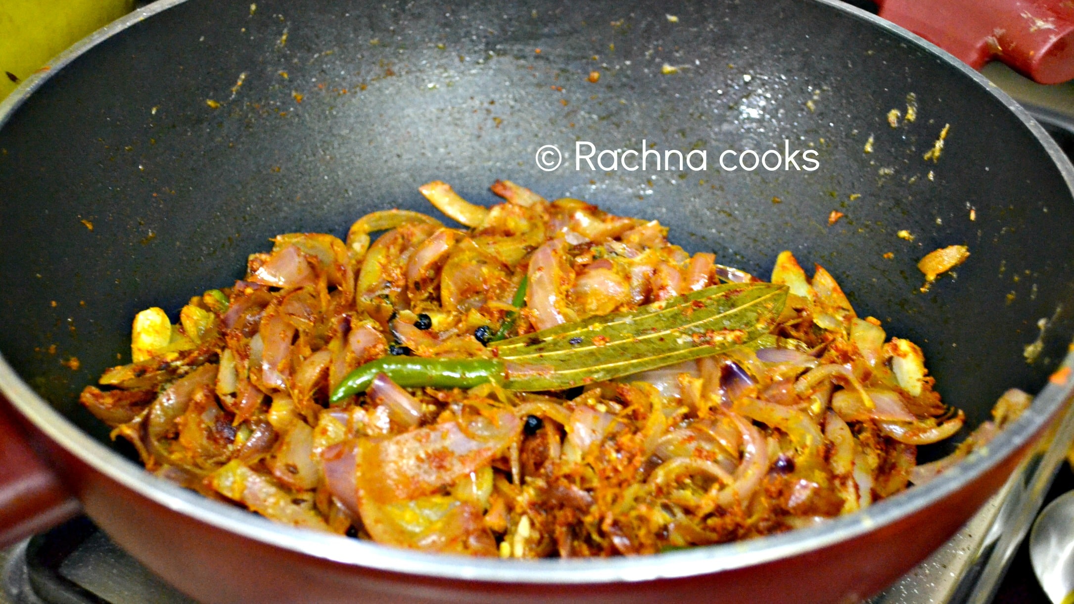 Sauteed curry masala with fried onions, whole spices, green chillies in a wok