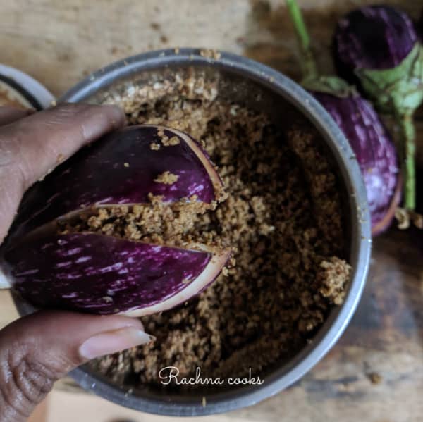 Each small aubergine with small slits and stuffed with the roasted powdered spice mix