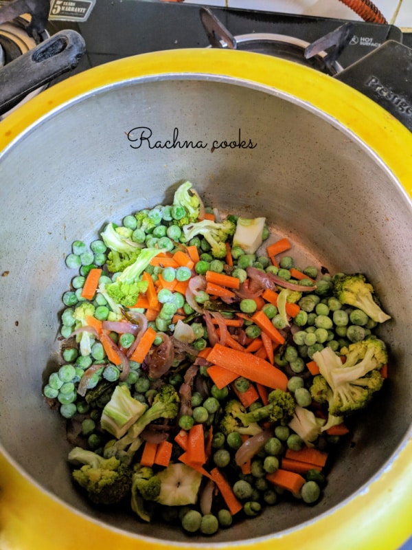 Broccoli, frozen peas, carrots cut in batons are added in the pressure cooker