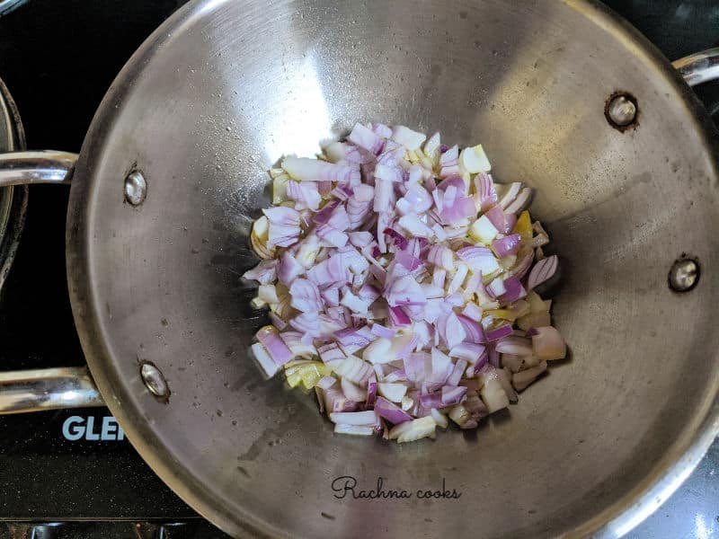 Chopped onions being sauteed in a pan.
