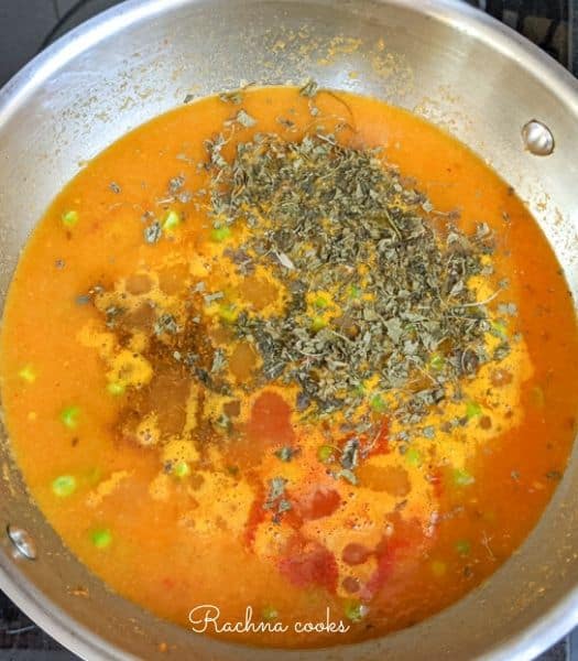 Adding spice powders to the matar paneer curry